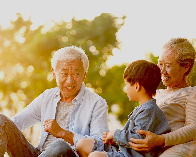 An old man laughs and talks to his grandson.