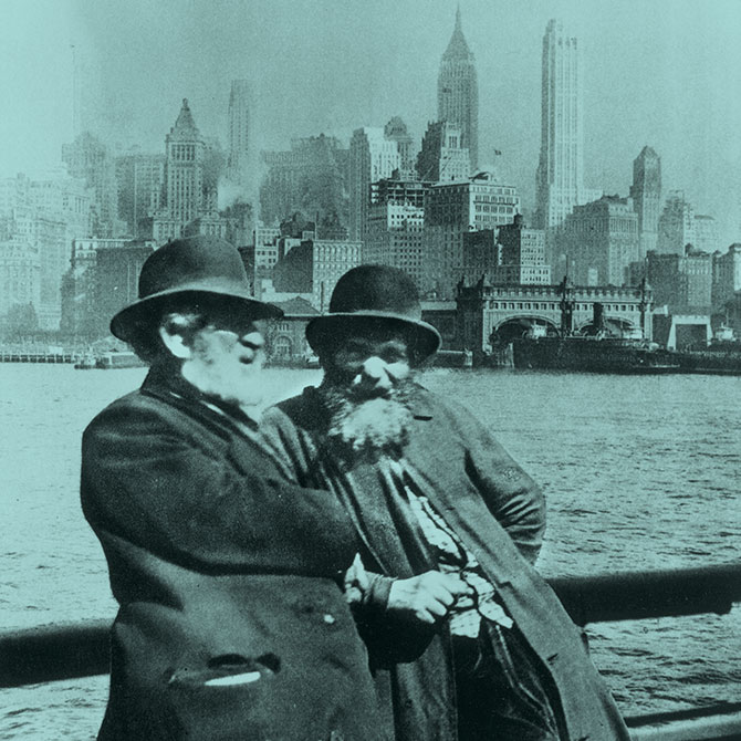 Two immigrants with New York City in the background.