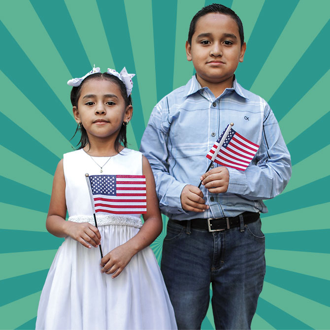A young boy and girl hold American flags.