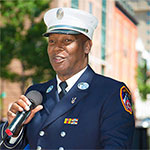 Person in uniform speaking into a microphone