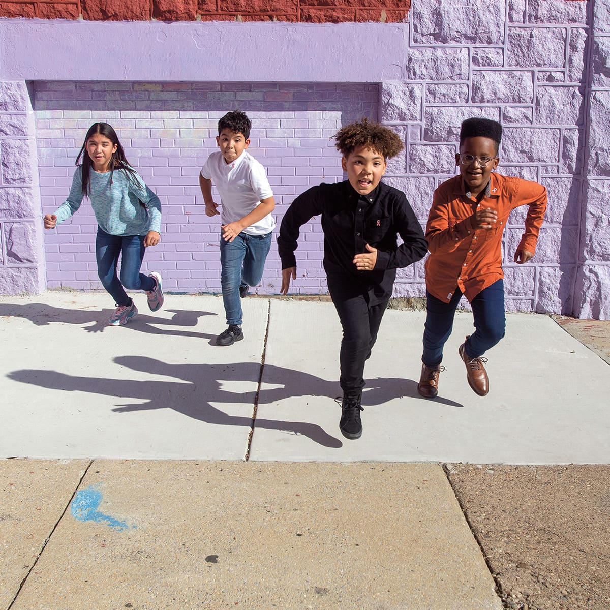 Photo of four students running