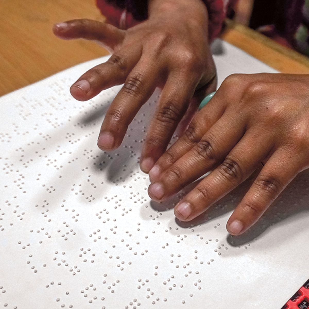 Image of a pair of hands reading Braille