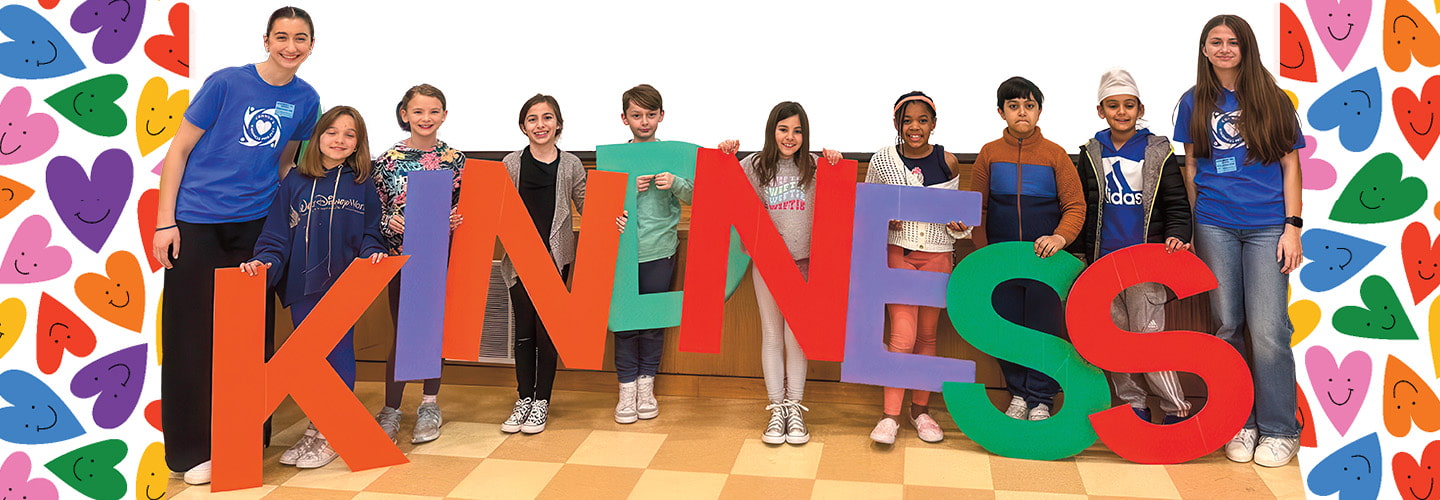 Photo of a group of students holding up people-sized letters spelling out "Kindness"